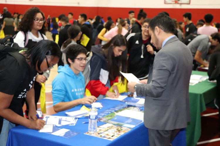 Joel Ortega of Aurora University talks to students about his college programs.