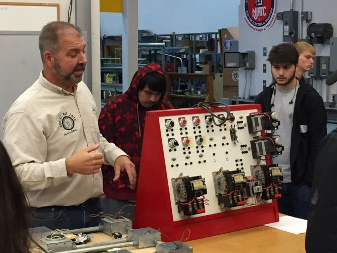 Mike Angelo of the IBEW 461 shows students an electrical panel.